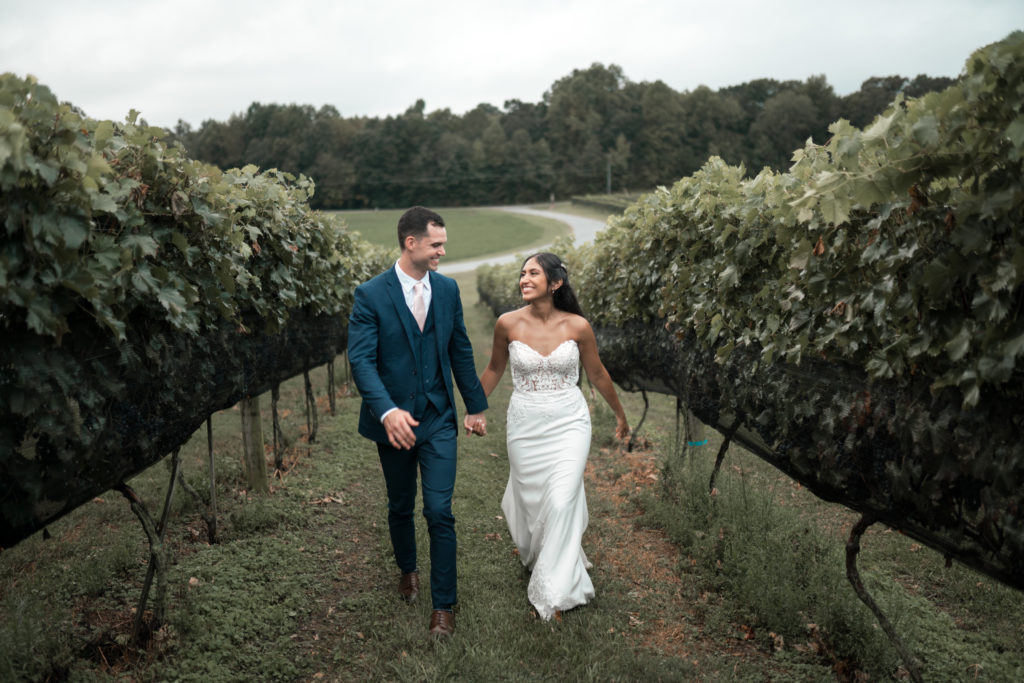 The Venue at Cenita bride and groom walking through vineyards after ceremony